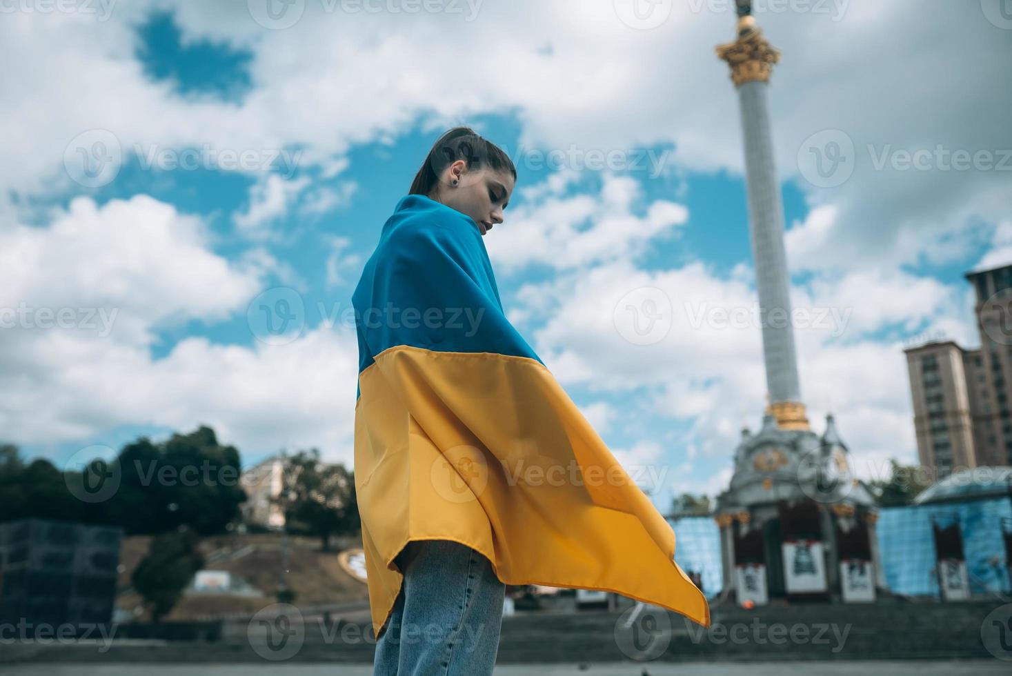 Young woman covered with the Ukrainian flag photo