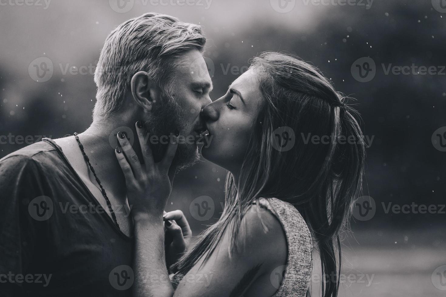 beautiful couple kissing in the rain photo