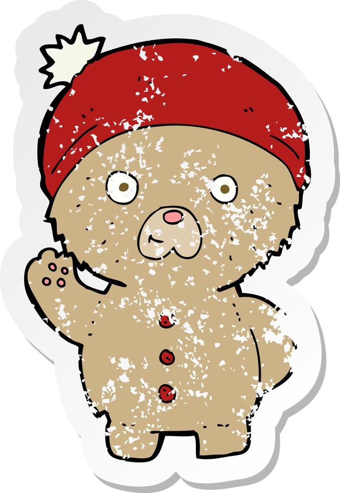 retro distressed sticker of a cartoon waving teddy bear in winter hat vector