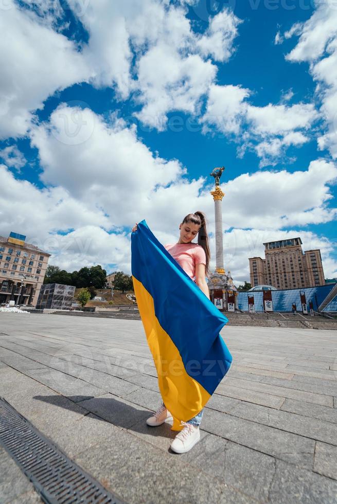 mujer joven con bandera nacional de ucrania en la calle foto