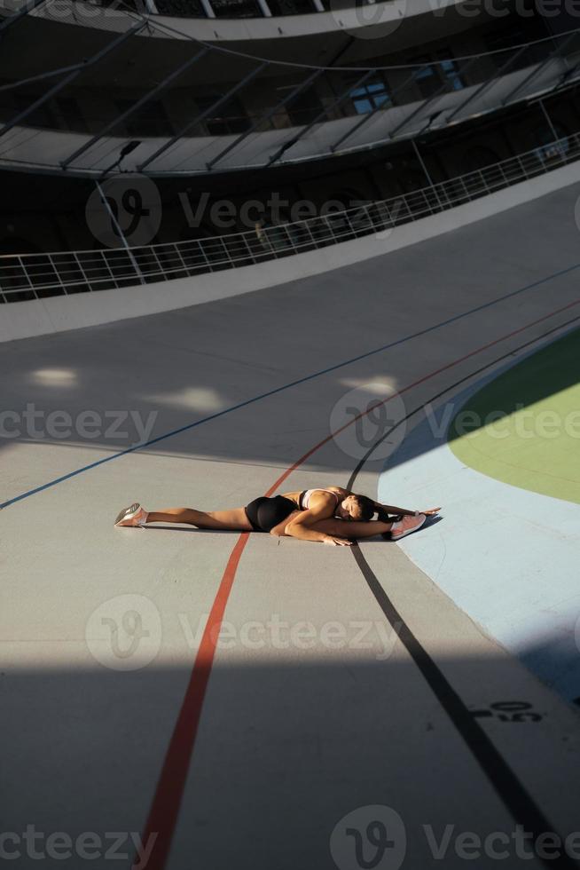 Young attractive female fitness woman performing a twine photo