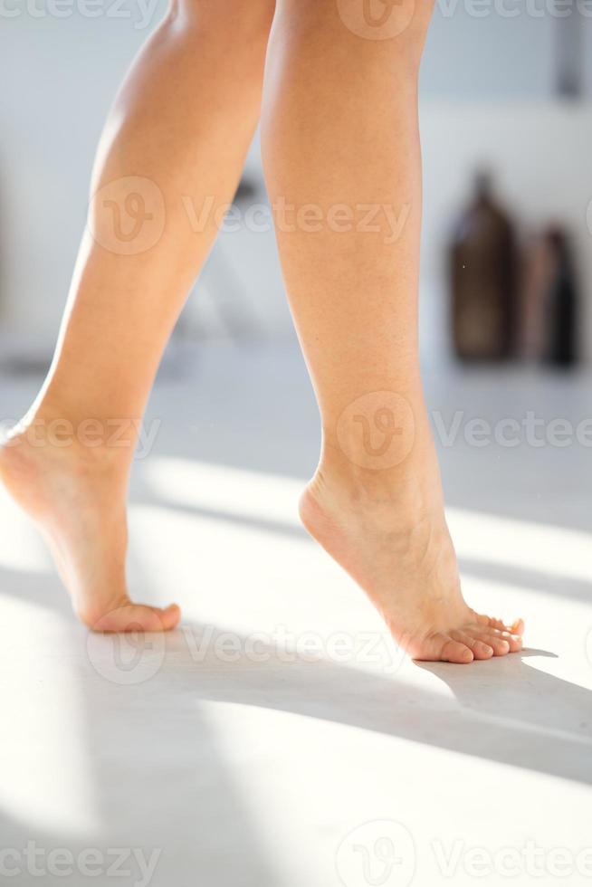 Female feet walking on floor close up view photo