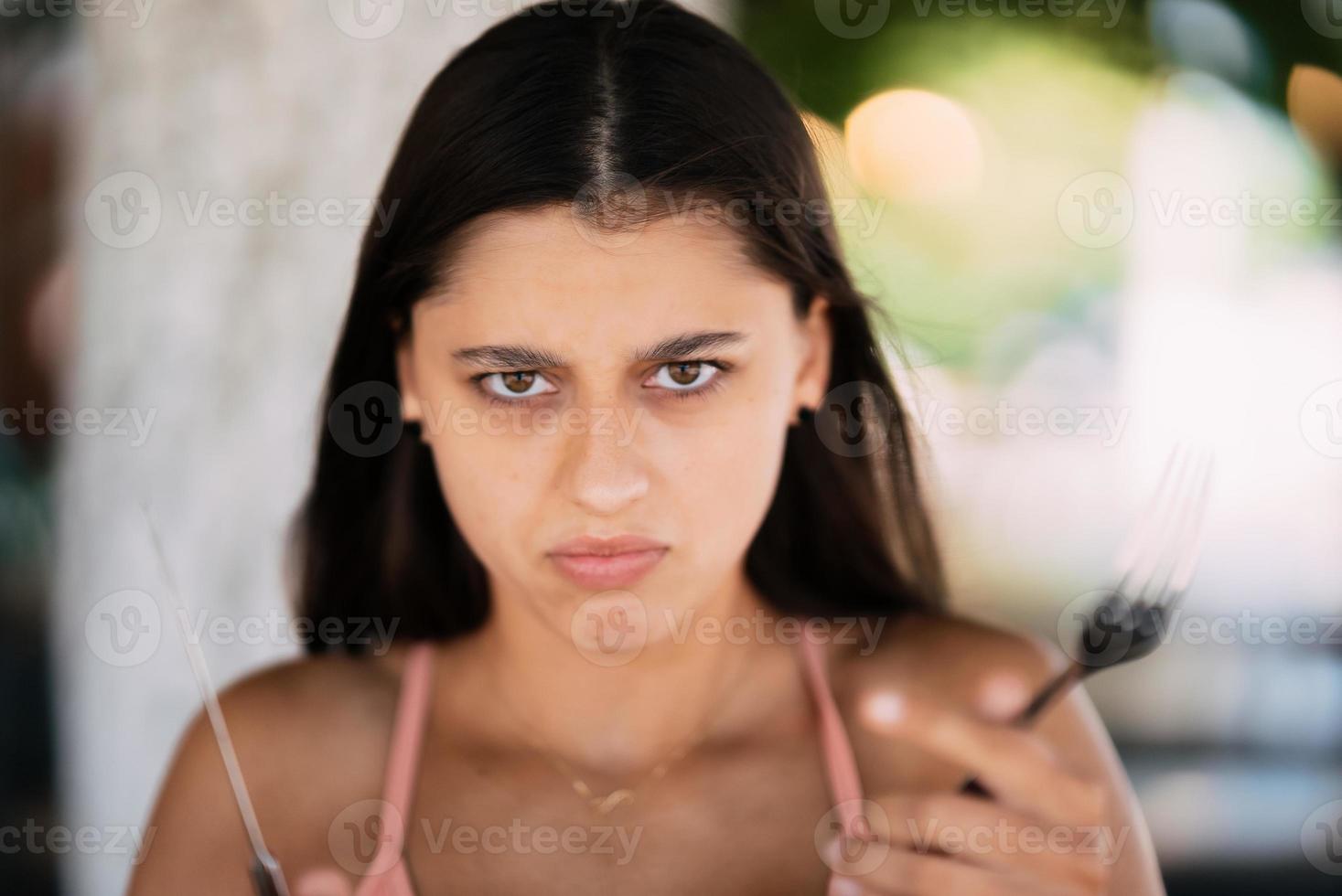 Young beautiful woman holding a knife and a fork photo