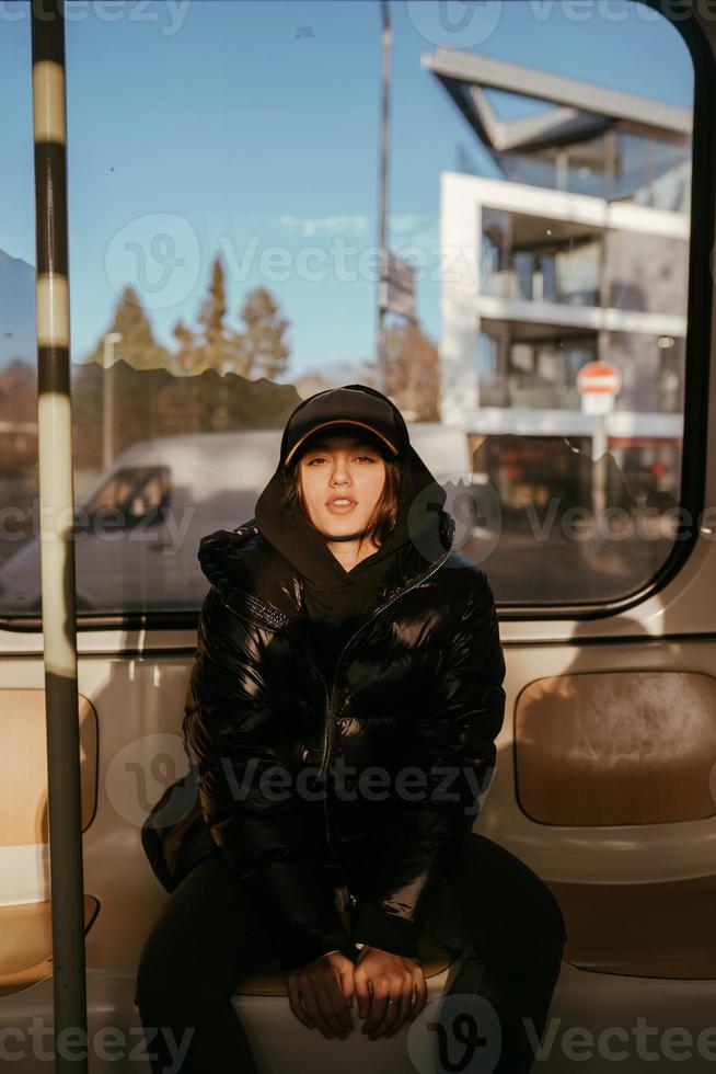 Young woman sitting on the background of a window in public transport photo