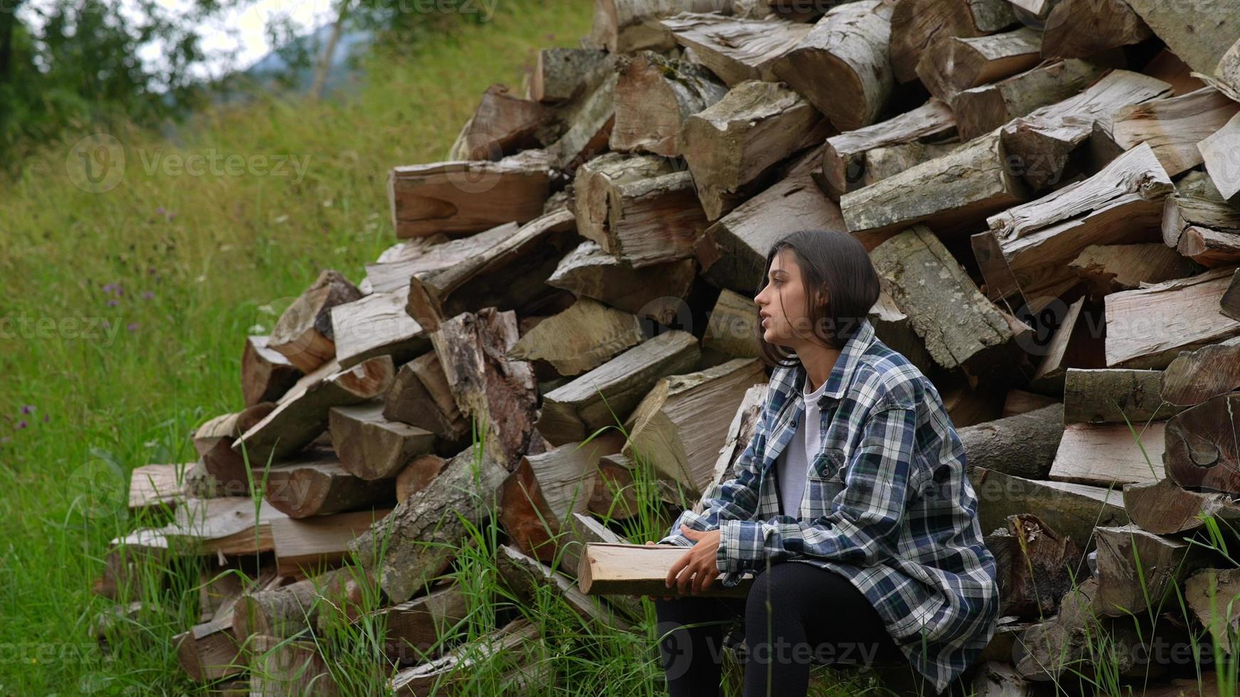 Woman in the forest near the pole of chopped wood photo