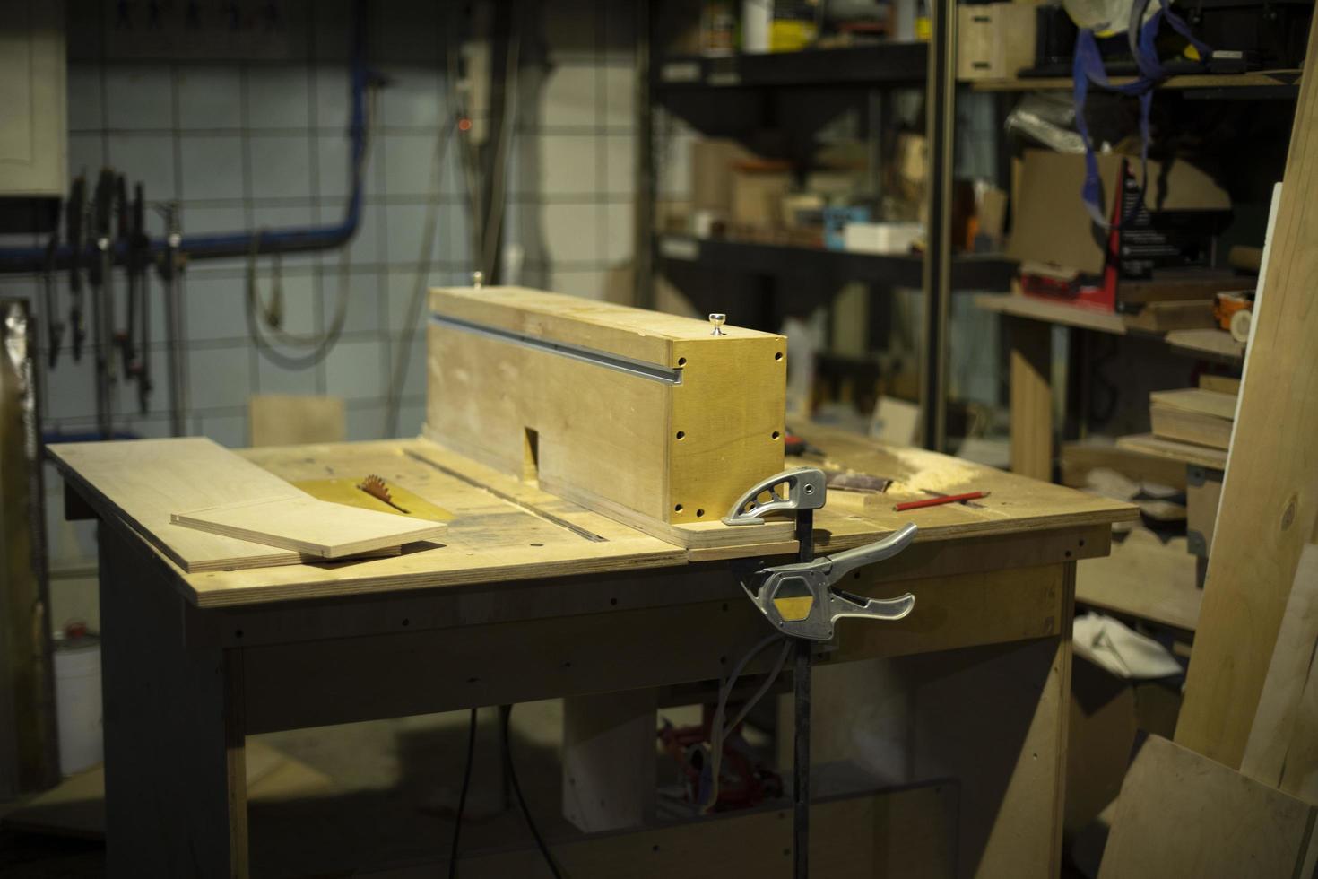 Table in wood workshop. Furniture assembler's workplace. Boards lying on table. photo