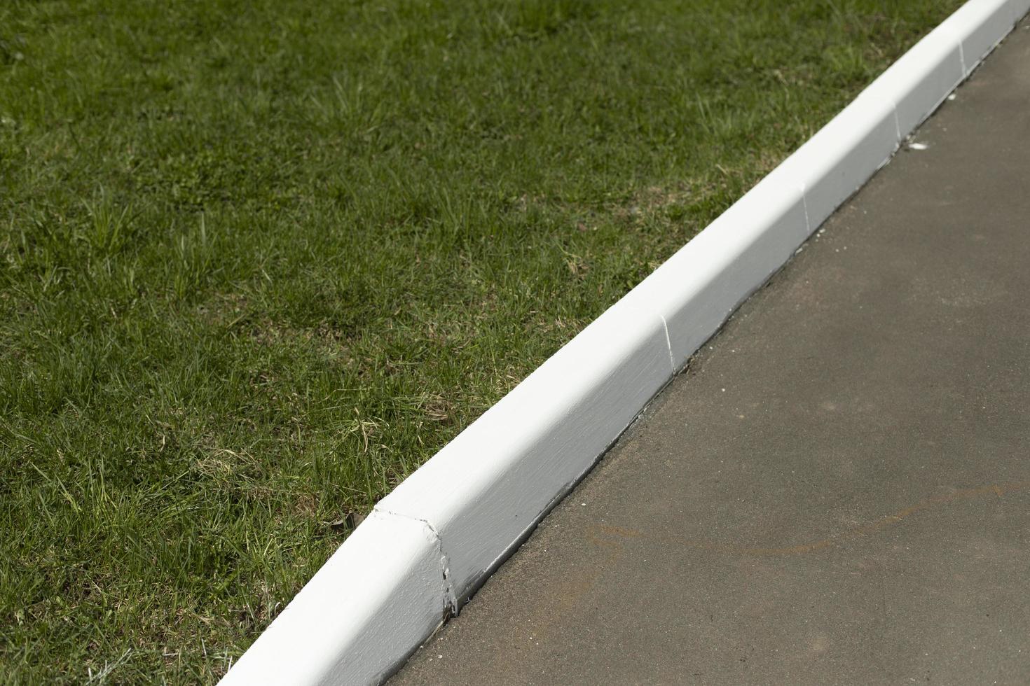 White curb on road. Landscaping in park. photo
