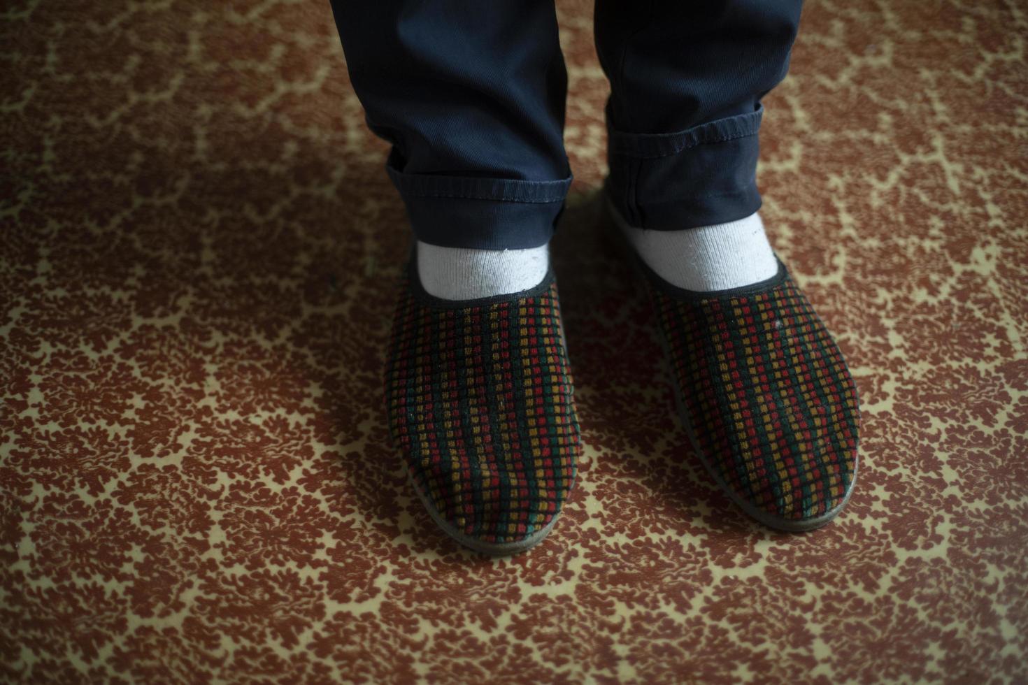 Slippers on feet. Guy's feet are in slippers. photo