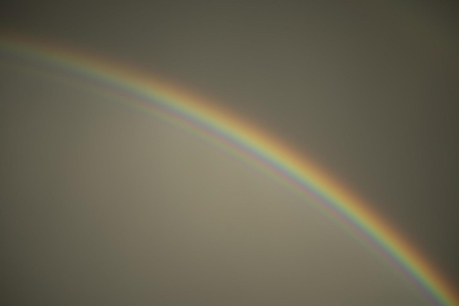 Rainbow in sky. Refraction of light. Weather after rain. Bright arc of different colors. photo