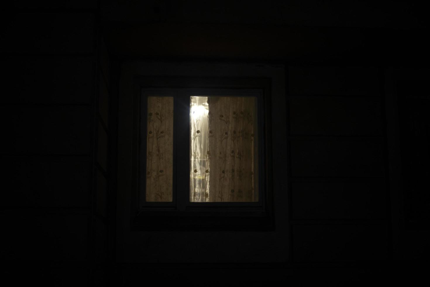 Window is in dark. Curtains on window at night. photo