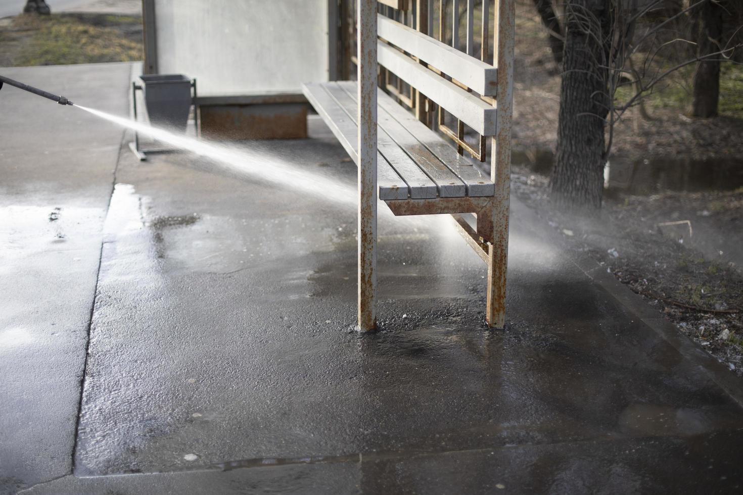 Cleaning on street. Washing bus stop in Russia. High pressure water flow. photo