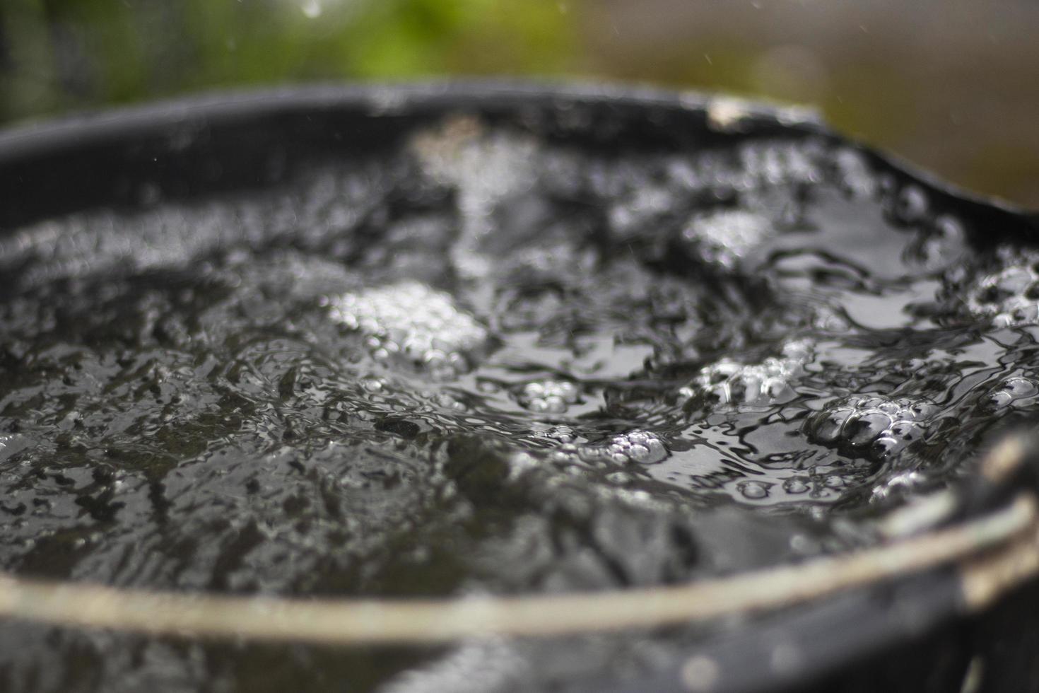 Drops of water. Water in bucket. Rain is falling. photo