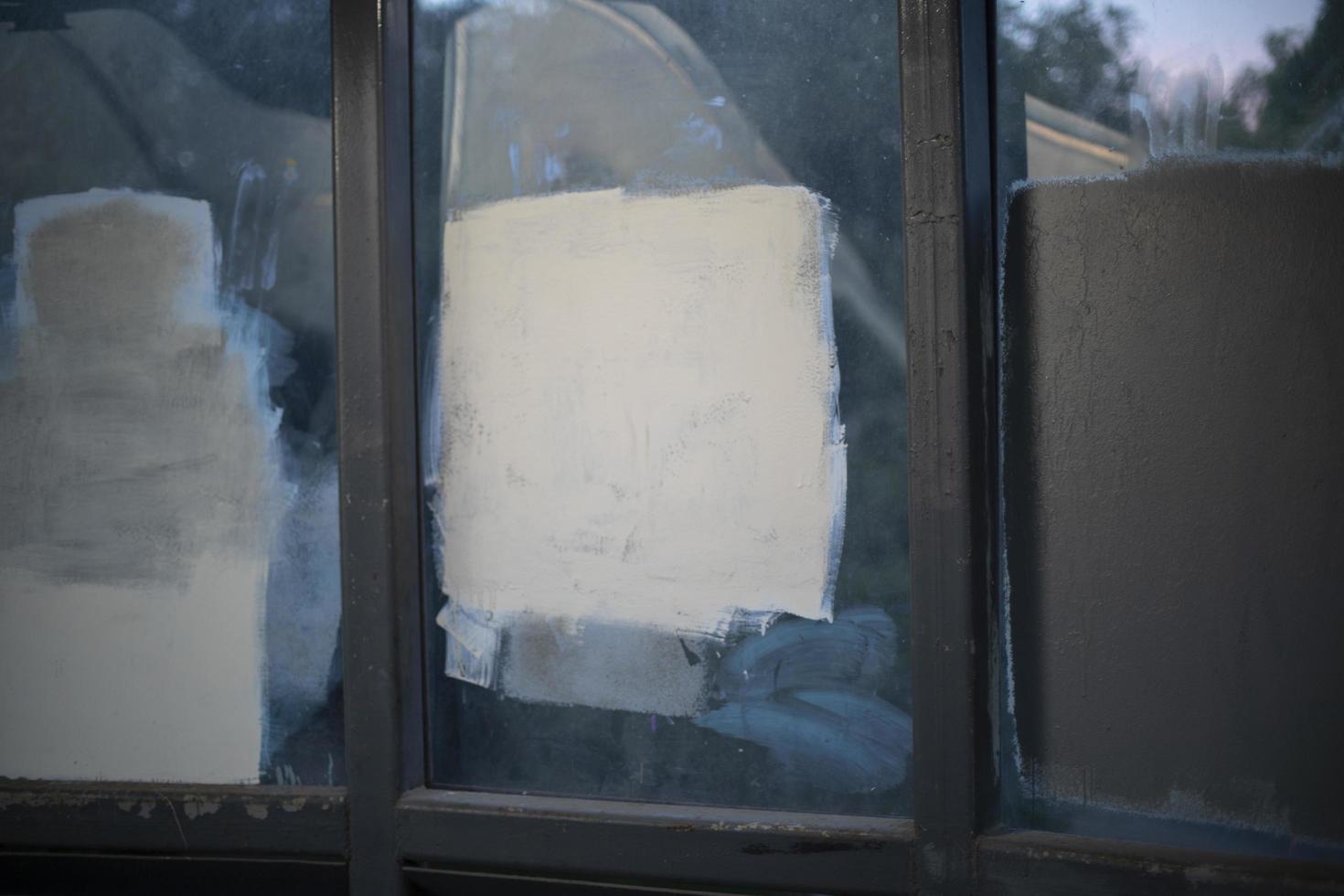 Painted over graffiti. Fight against vandalism. White square on glass. photo