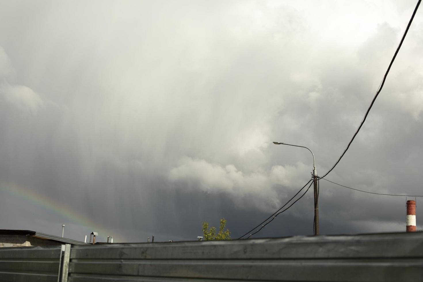 Rainbow in rainy sky. Celestial landscape in industrial area. photo