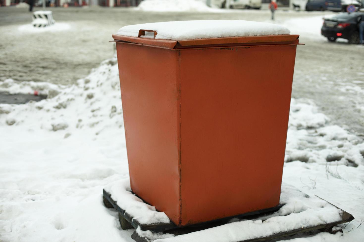 Steel tank. Dumpster. Place to store sand on highway. Orange object in winter on road. photo