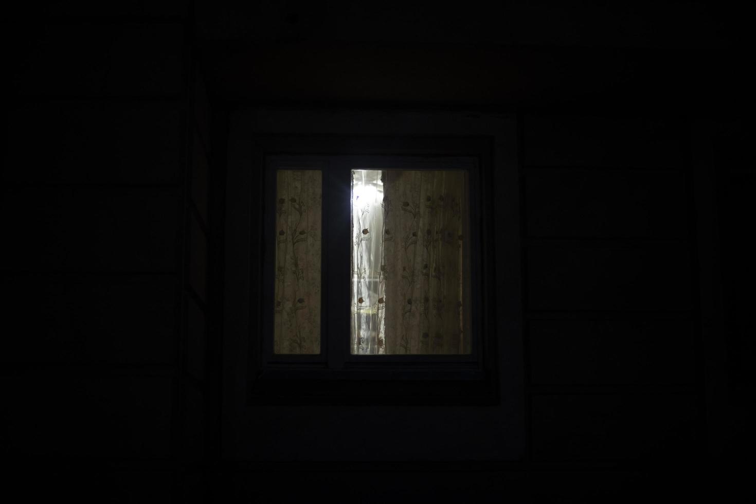 Window is in dark. Curtains on window at night. photo