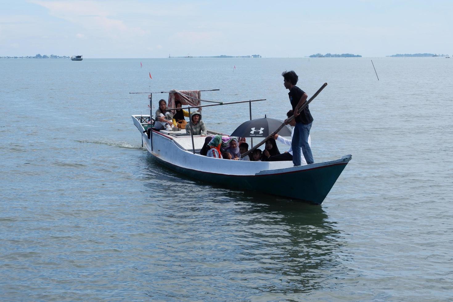 South Sulawesi, Indonesia - April 25, 2022, Boat contains many people cross on the sea photo
