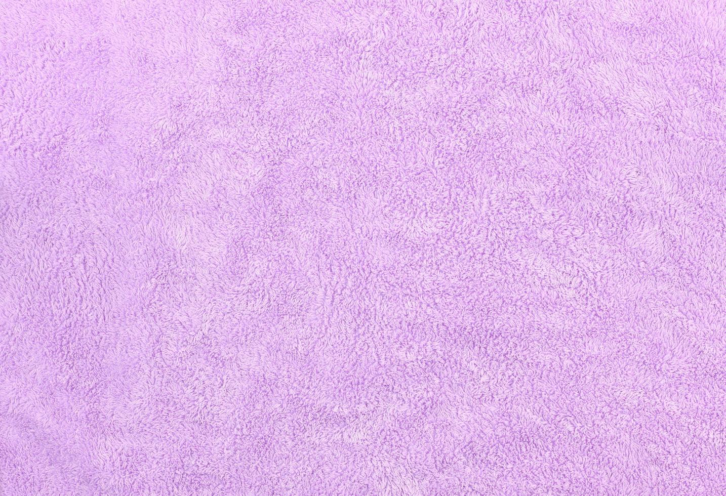 Flat lay of purple fluffy towel fabric texture. Blank and soft bathroom carpet surface. photo