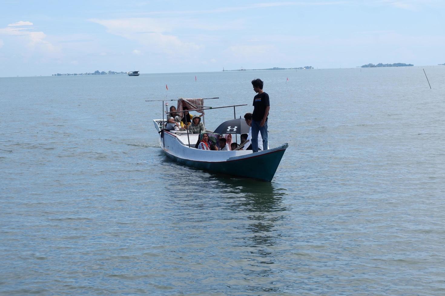 South Sulawesi, Indonesia - April 25, 2022, Boat contains many people cross on the sea photo