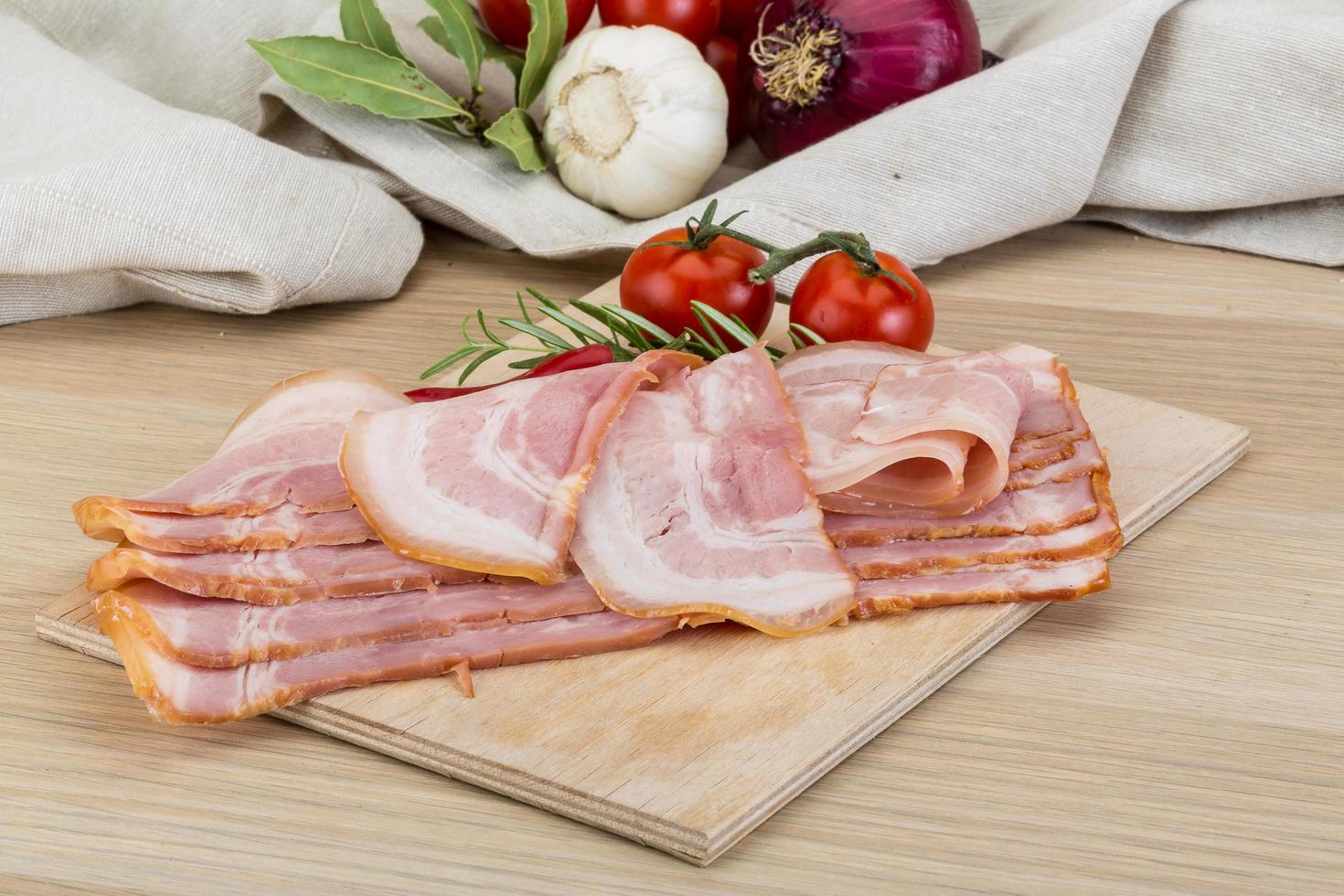 Bacon on wooden board and wooden background photo