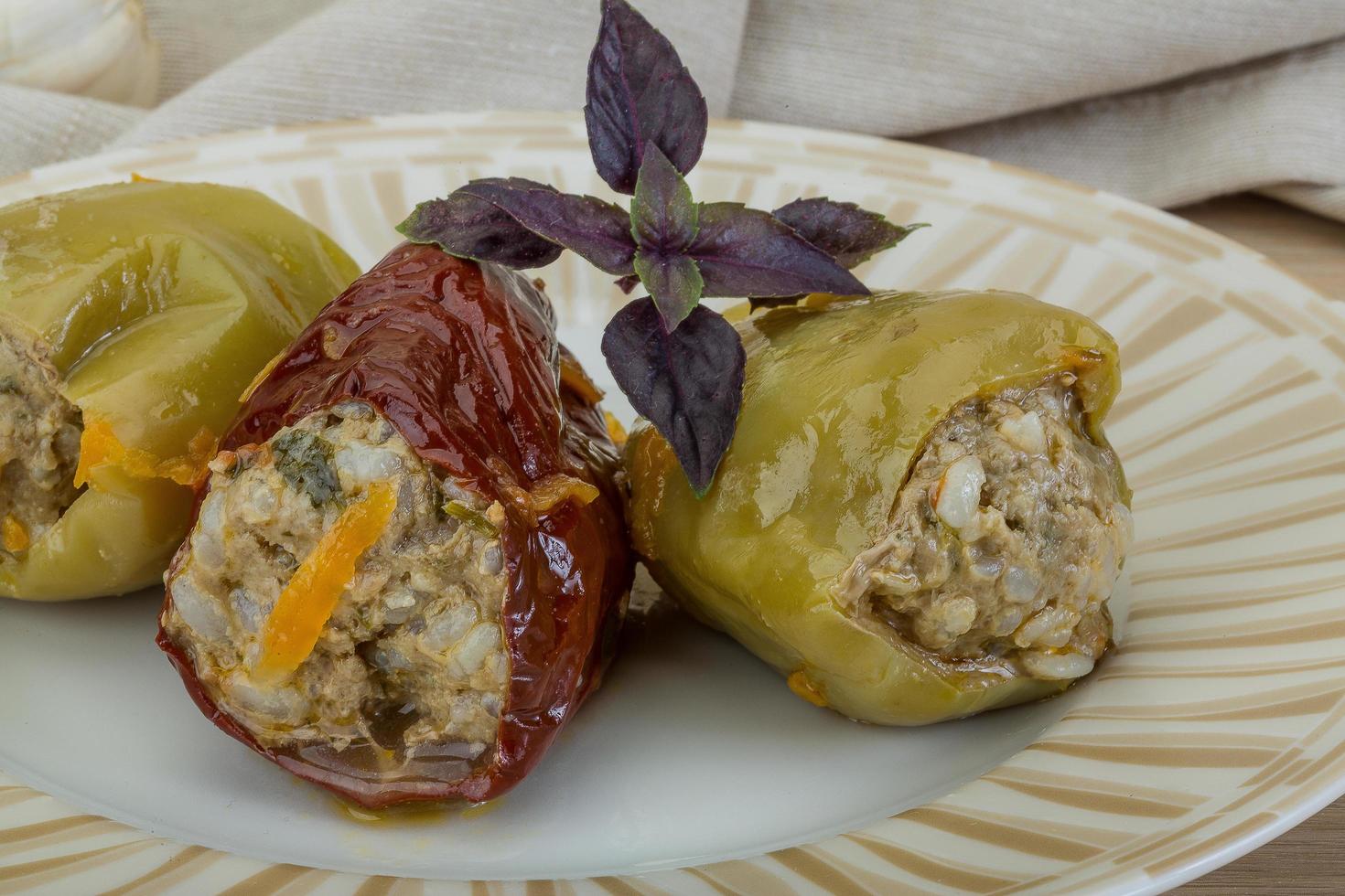 Stuffed peppers on the plate and wooden background photo