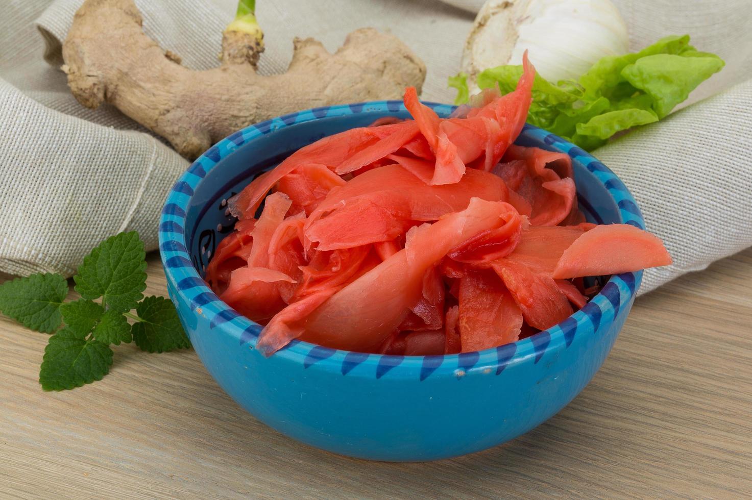 Marinated ginger in a bowl on wooden background photo