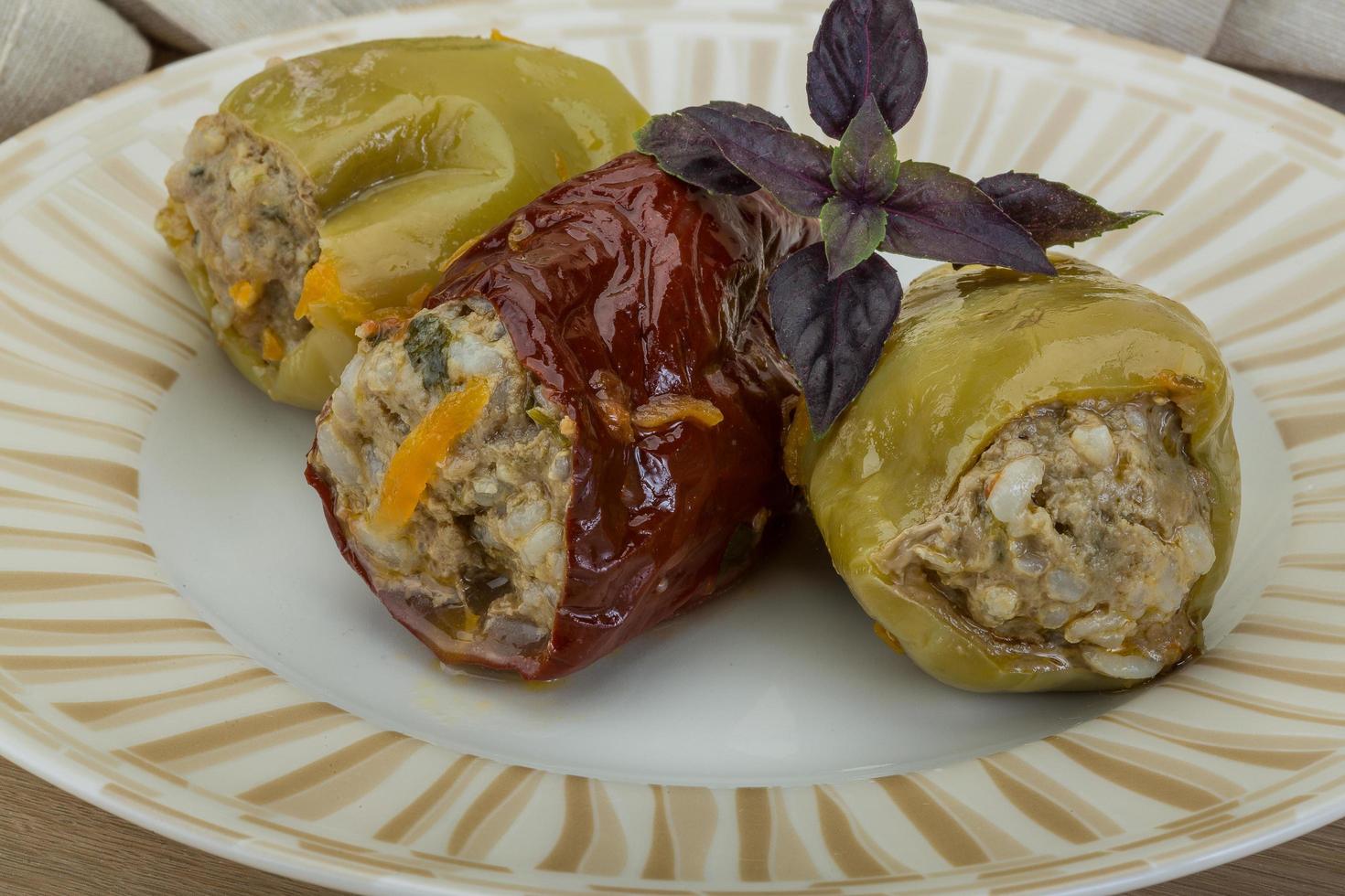 Stuffed peppers on the plate and wooden background photo