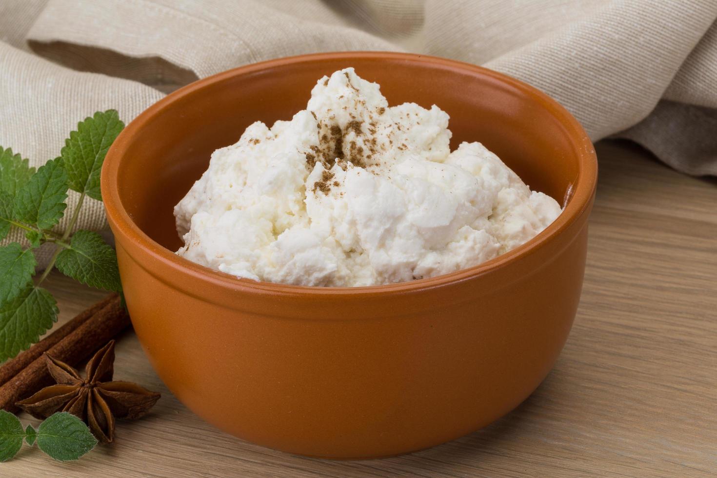 Ricotta cheese in a bowl on wooden background photo