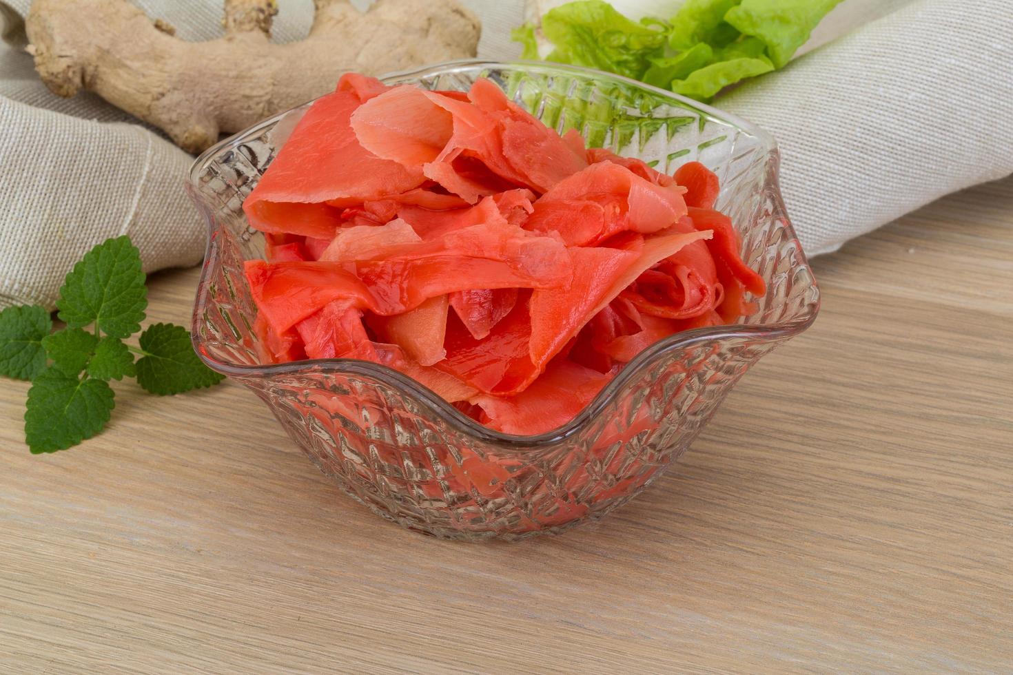 Marinated ginger in a bowl on wooden background photo