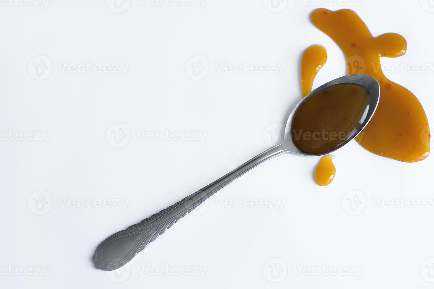 the drops of homemade sauce and a spoon on a white background photo