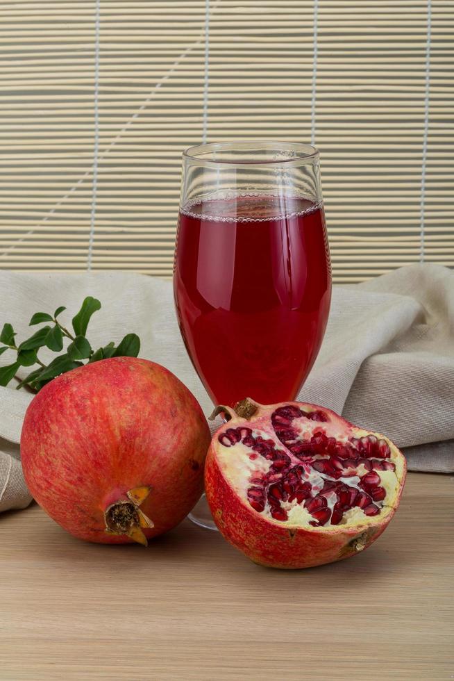 Pomecranet juice on wooden background photo