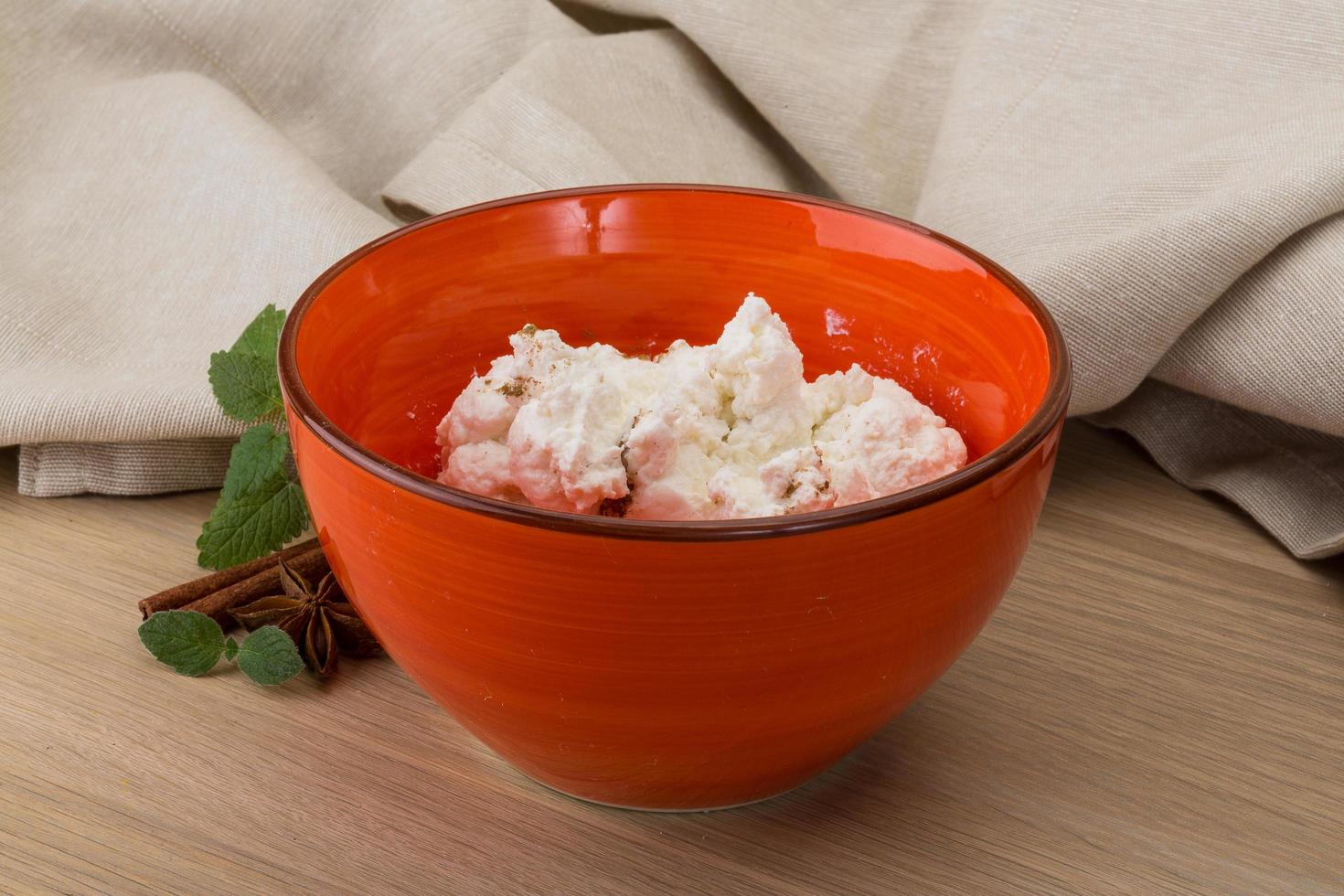 Ricotta cheese in a bowl on wooden background photo