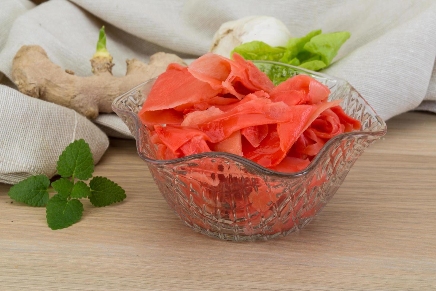 Marinated ginger in a bowl on wooden background photo