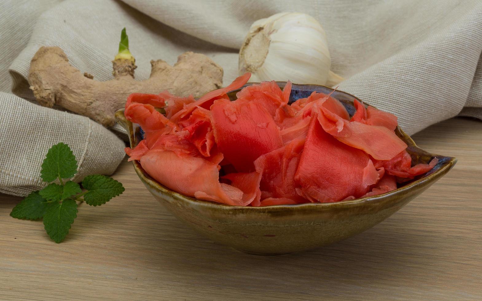 Marinated ginger in a bowl on wooden background photo