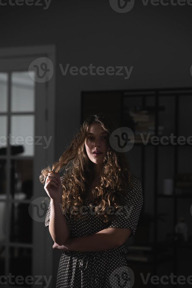 Serious beautiful young woman in dress posing for the camera. photo