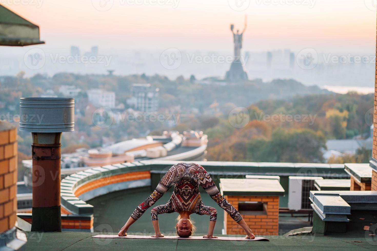 mujer haciendo yoga en la azotea de un rascacielos en la gran ciudad. foto