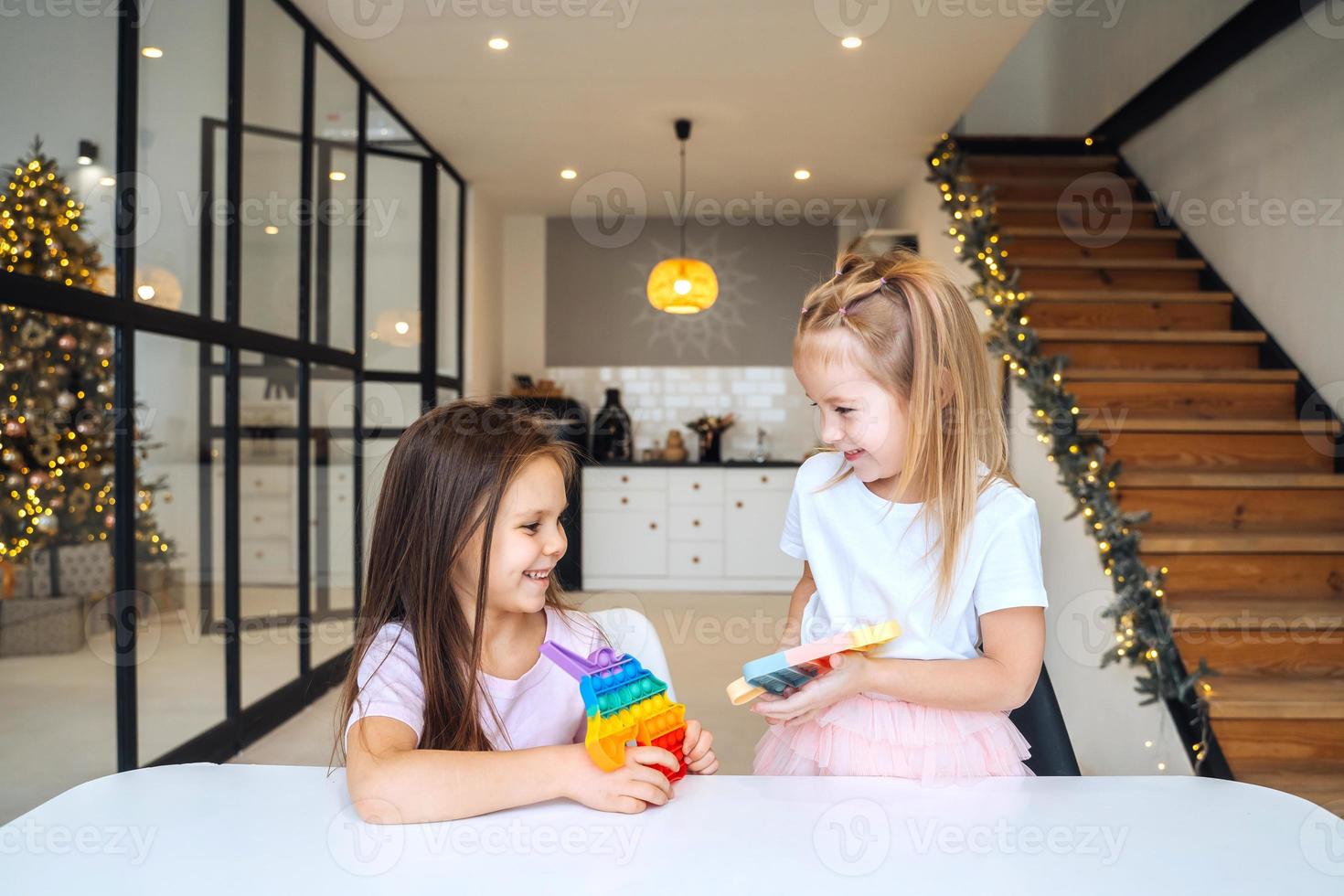 Photo of two little girls playing at the table on the camera