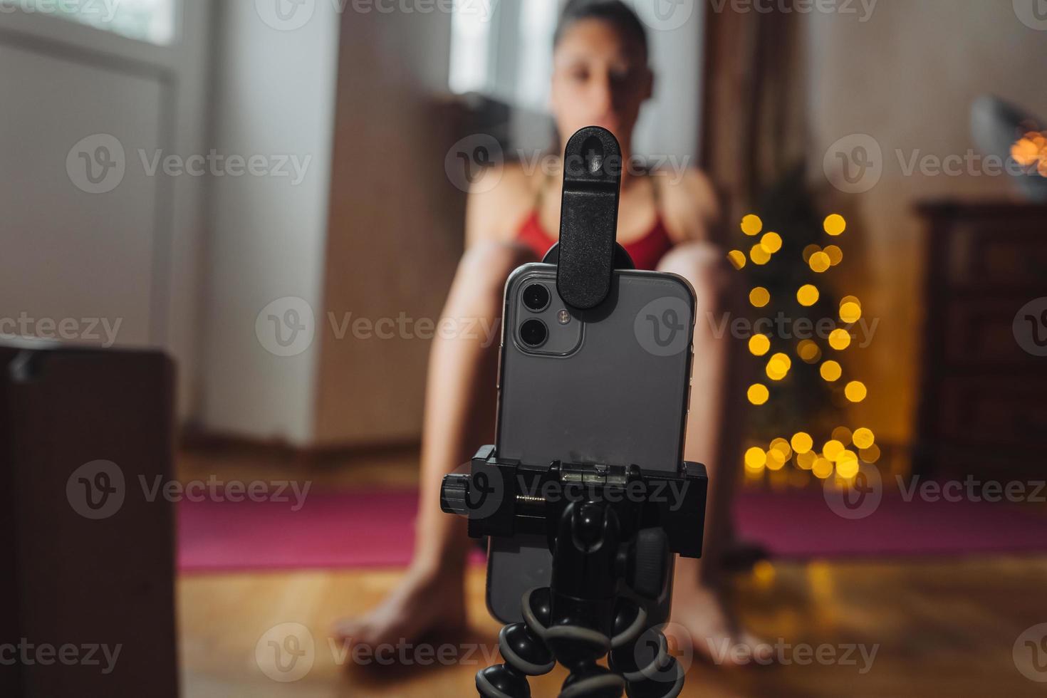 Young woman practicing yoga, is engaged with the teacher online. photo