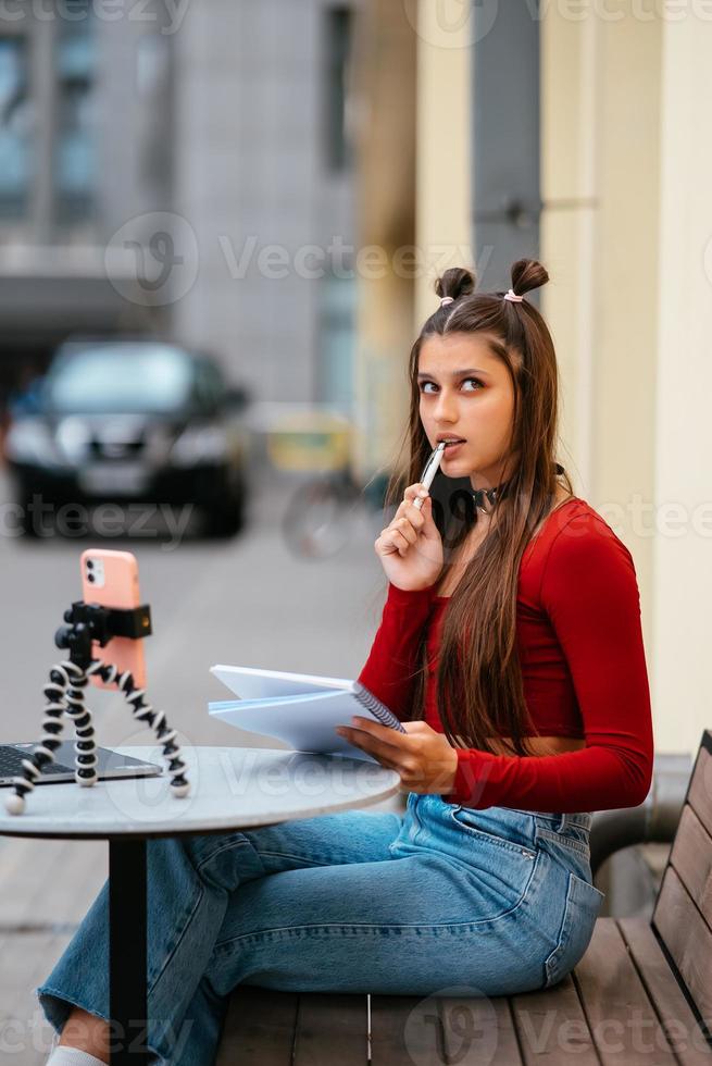 Freelancer woman in a summer cafe doing remote work. photo