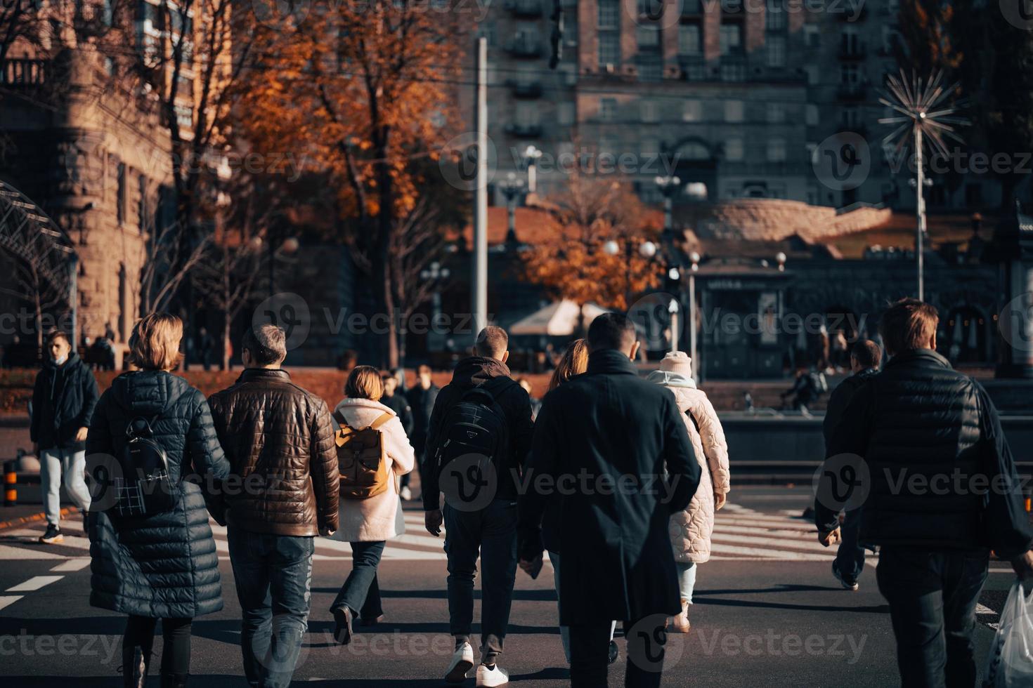 Lots of people crossing the street at the traffic lights. photo