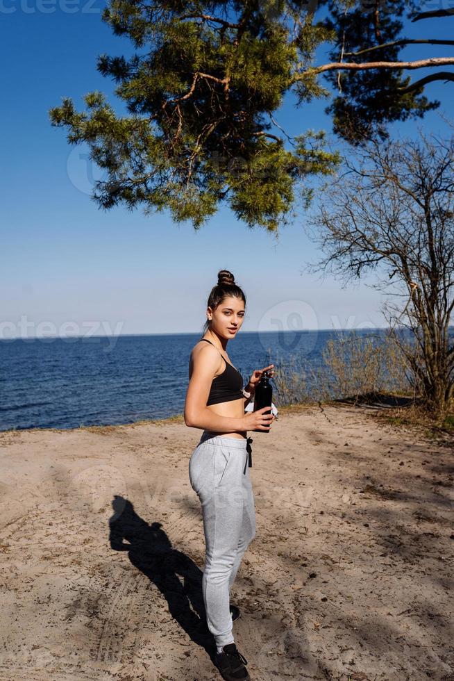 Fitness young woman walks in the park and posing for the camera photo