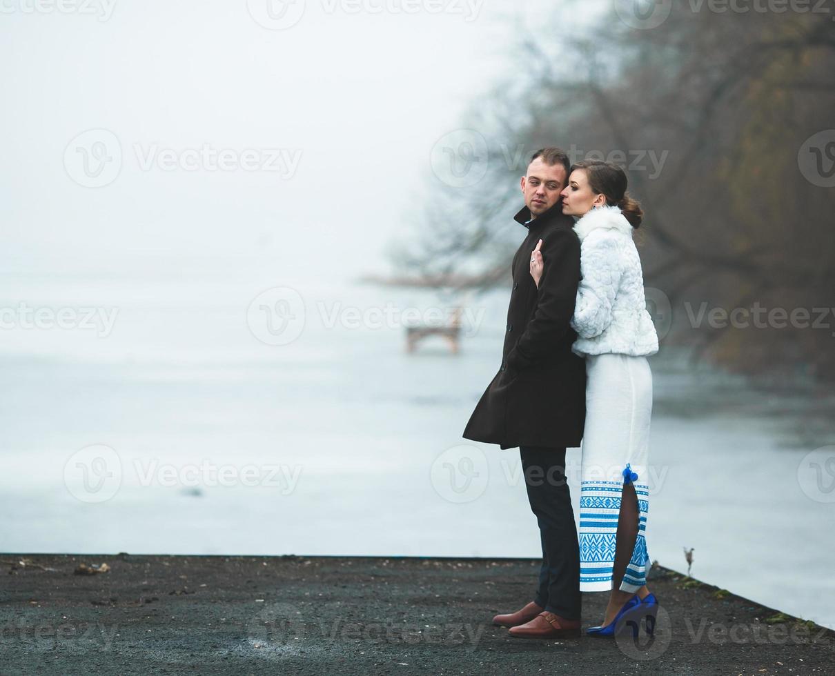 hermosa pareja en el muelle en la niebla invernal. foto