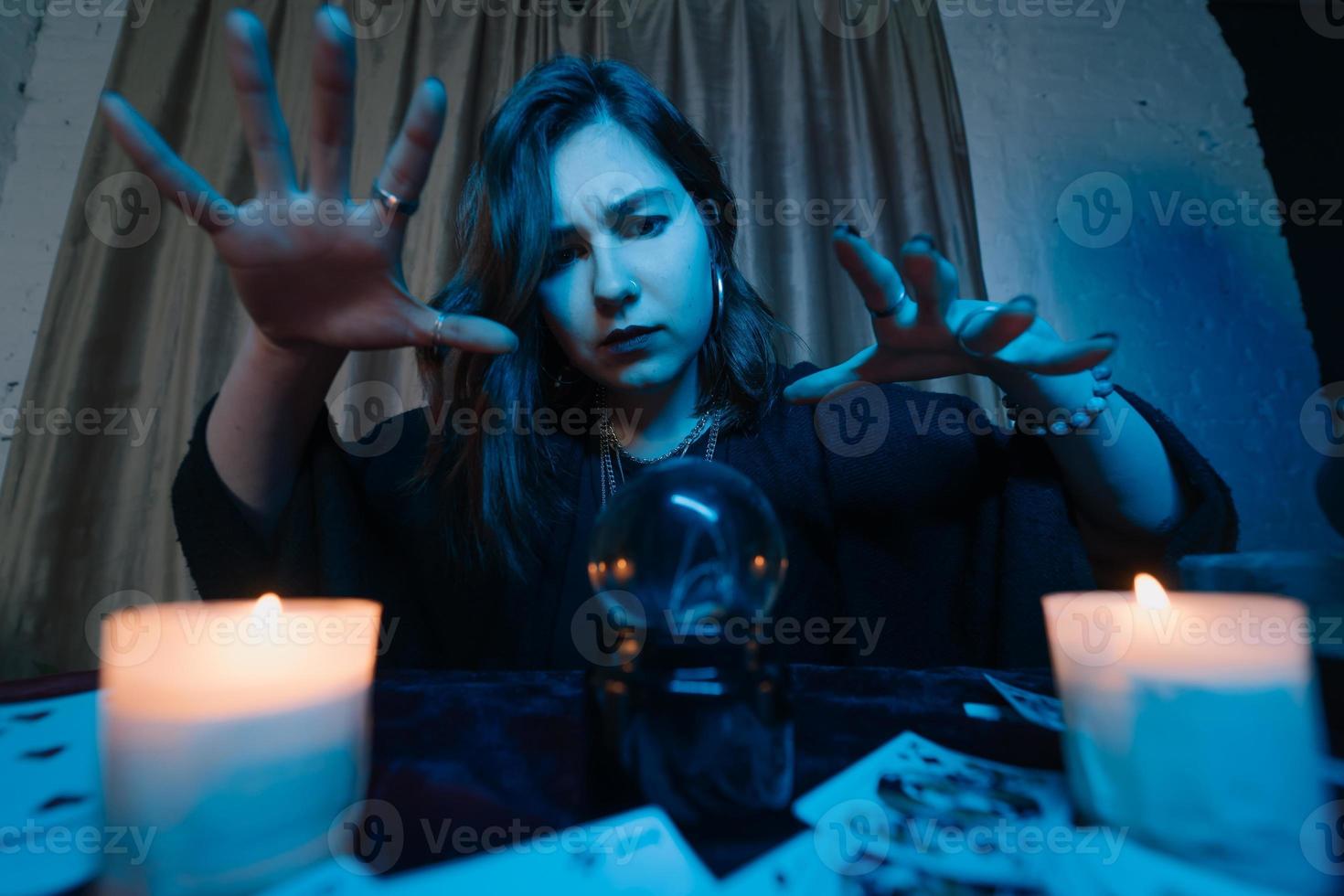 mujer adivina adivina el destino de la noche en la mesa con velas foto