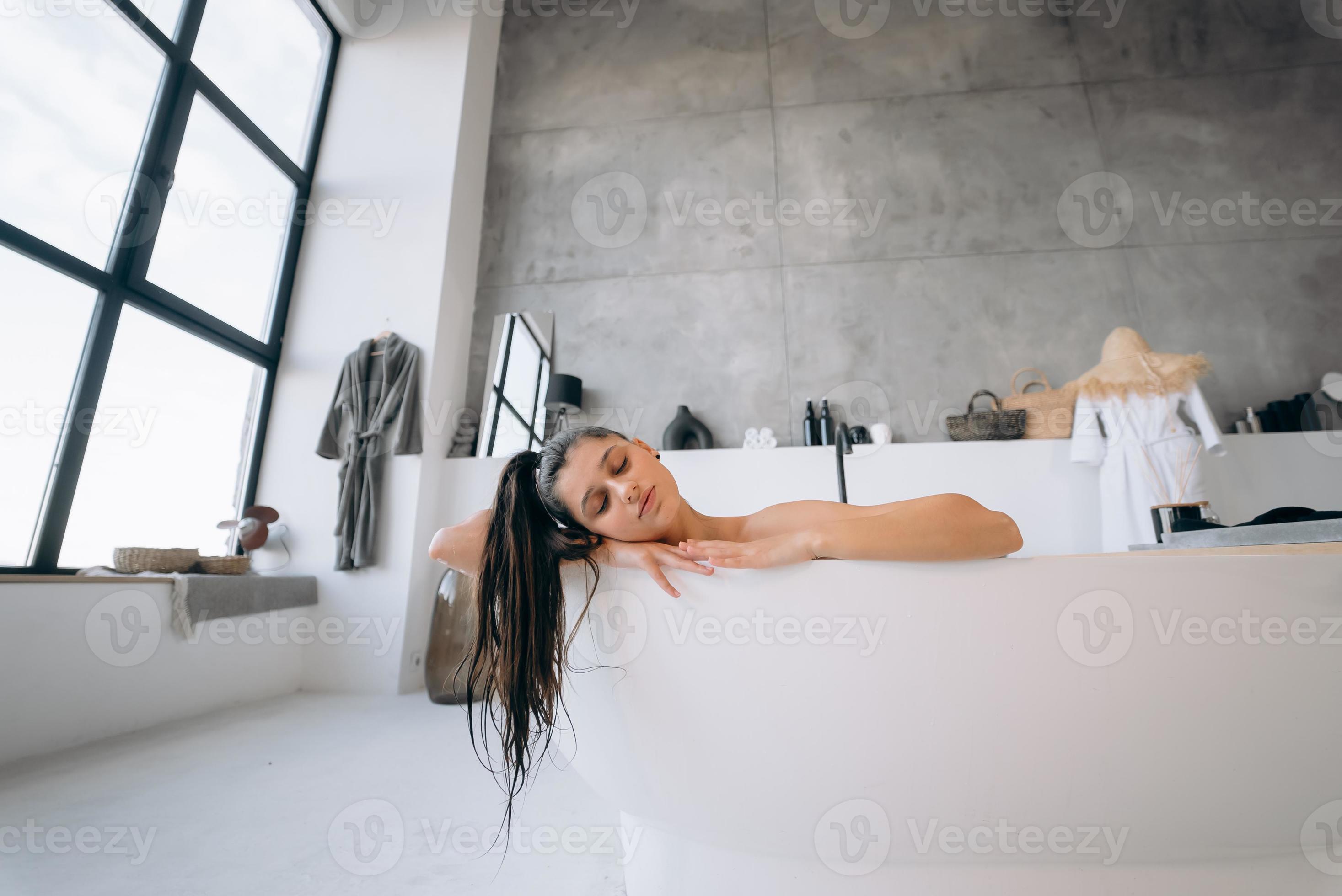 Relaxed lady taking bath, enjoying and relaxing while lying in bathtub