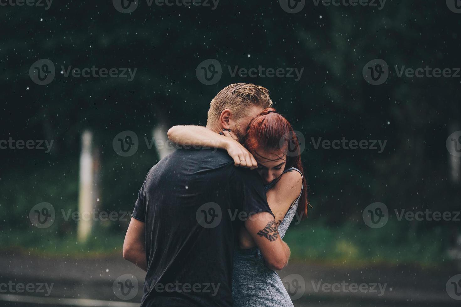 beautiful couple hugging in the rain photo