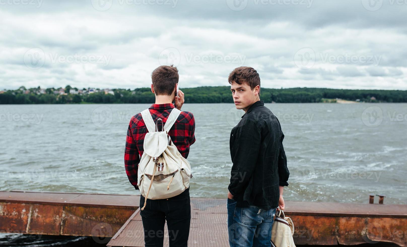 two young guys stand on the pier photo