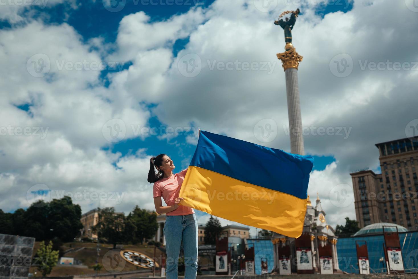 mujer joven con bandera nacional de ucrania en la calle foto