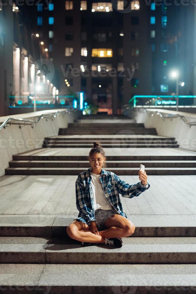 Woman talking via video call in the night city photo