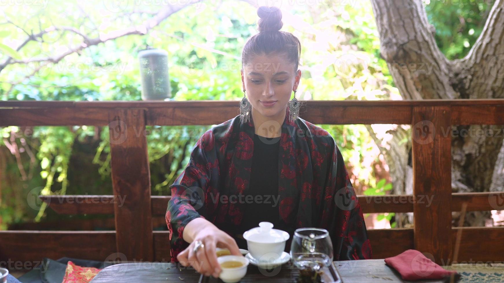 mujer joven demuestra un tazón de té a la cámara foto