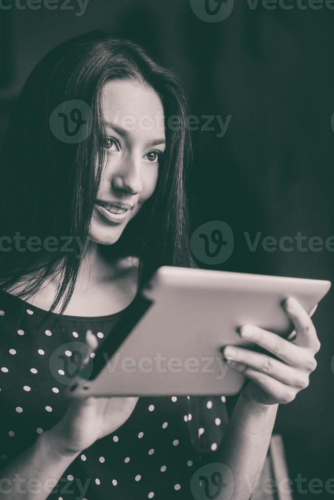 Beautiful girl working on a tablet and smiling photo